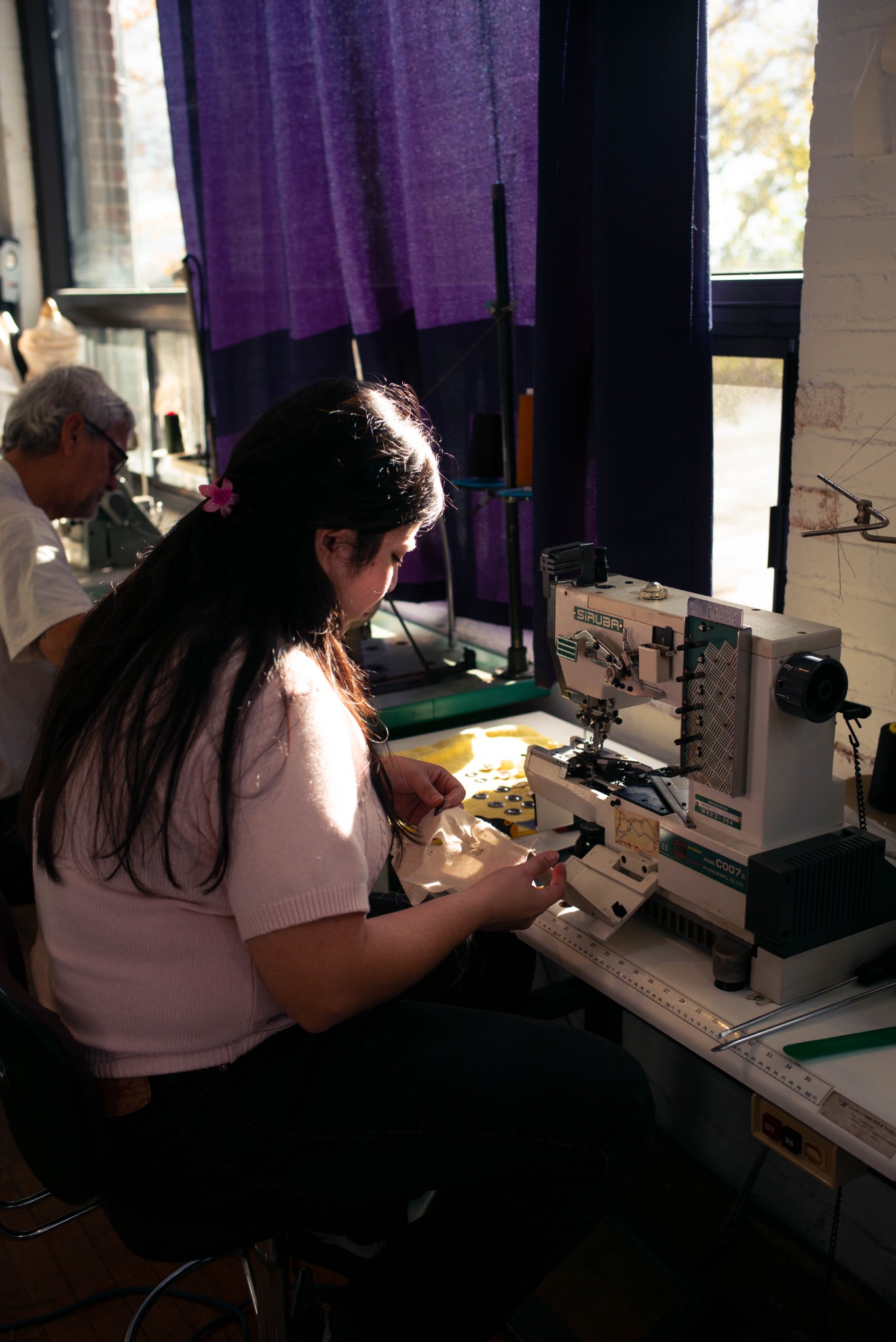 Working with fabric at an industrial sewing machine in the LDF studio.