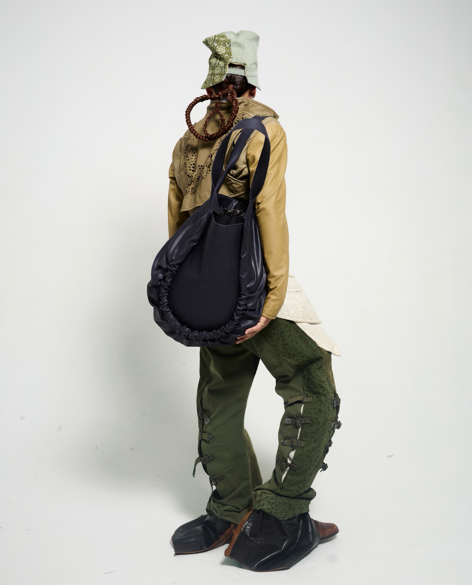 OSČ lookbook: rear view of the green look and an oversized dark shoulder bag.
