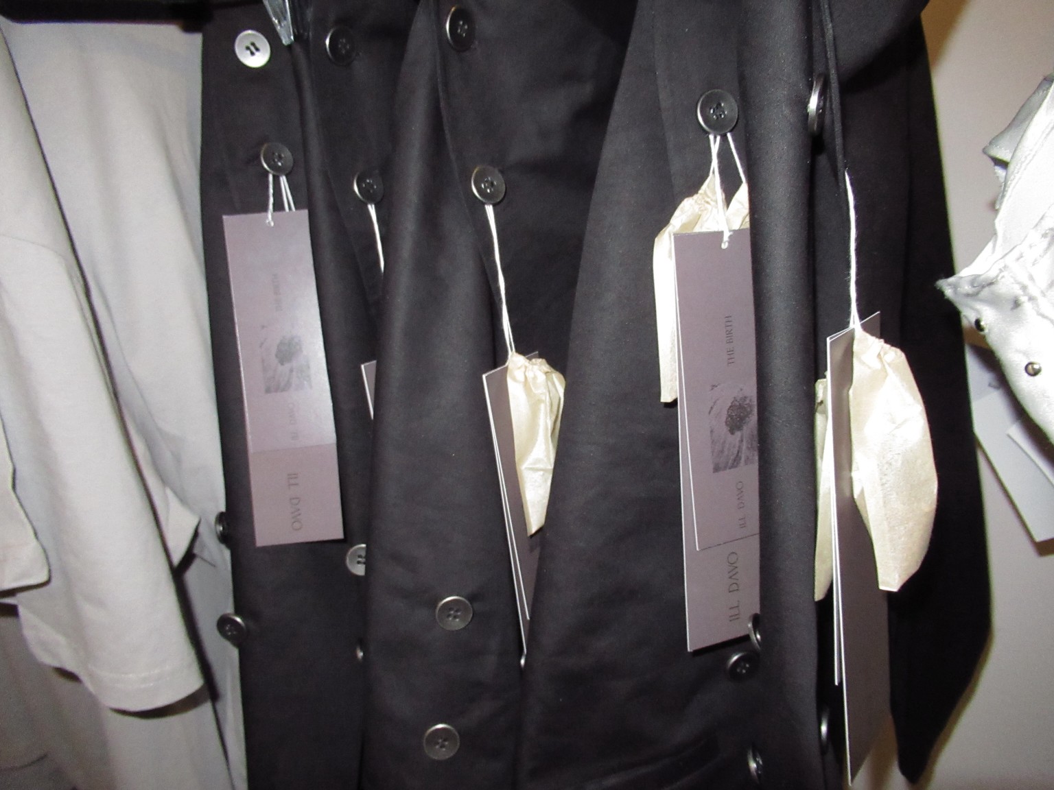 Vêtements noirs ILL DAVO avec étiquettes de collection dans le showroom multimarque de LDF.