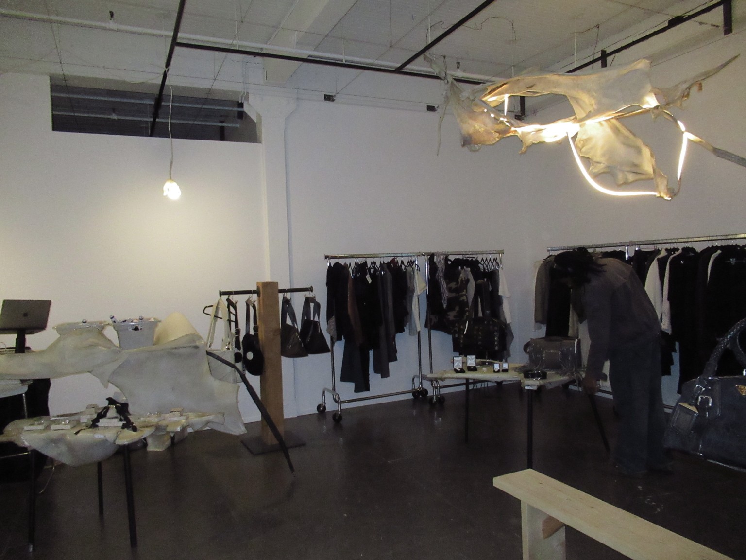 Vue du showroom multimarque LDF avec portants, mobilier sculptural et éclairage.