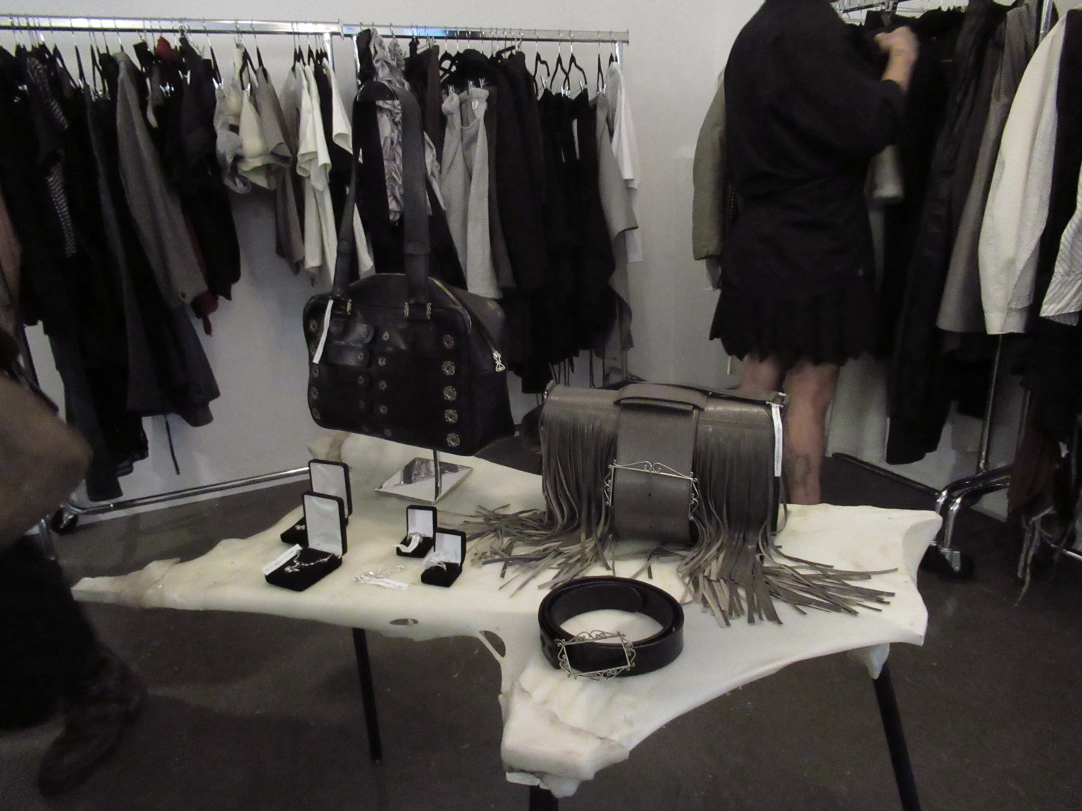 Sacs, bijoux et ceinture sur une table sculpturale parmi les collections du showroom LDF.
