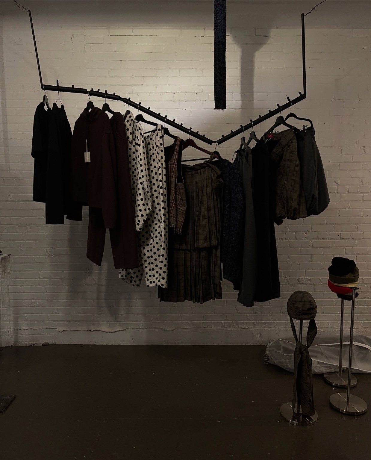 Vêtements de mode indépendante sur un portant sculptural au showroom LDF, Semaine de la mode de Montréal 2026.